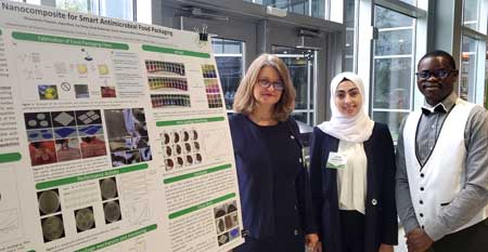 Silvana Andreescu (left) stands with two students presenting a poster on Food Spoilage Mitigation through packaging.