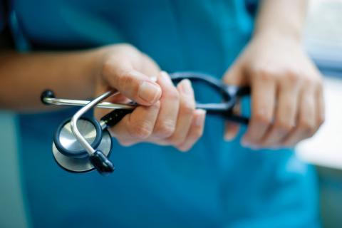 a medical professional holds a stethoscope