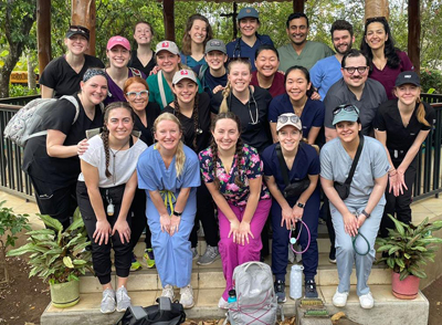 Group photo of 23 students and medical professionals posing on the steps of a rustic gazebo in Nicaragua 