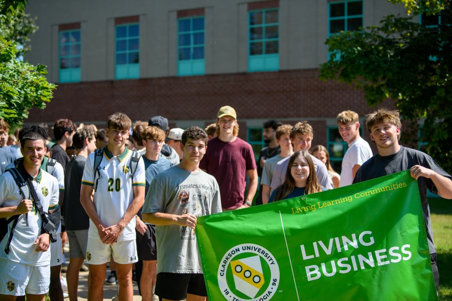 A photo of the Fall 2024 Living Business living learning community holding a banner