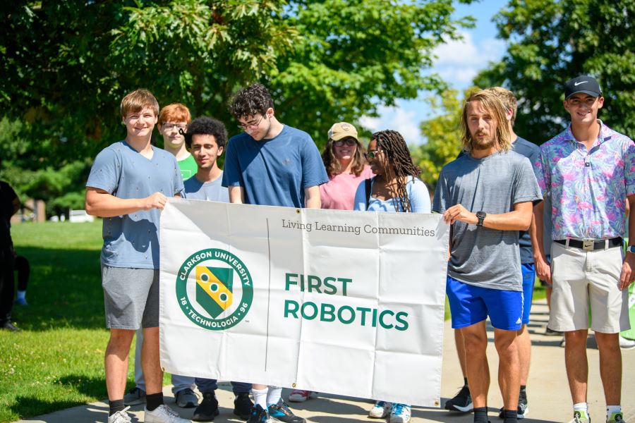 A photo of the fall 2024 first robotics living learning community holding a banner