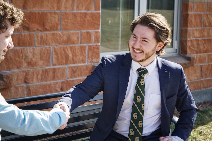 Two men shaking hands while smiling