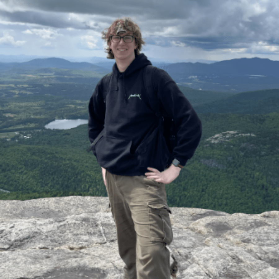 Cayden Fernandez Standing on a cliff with a landscape in the background