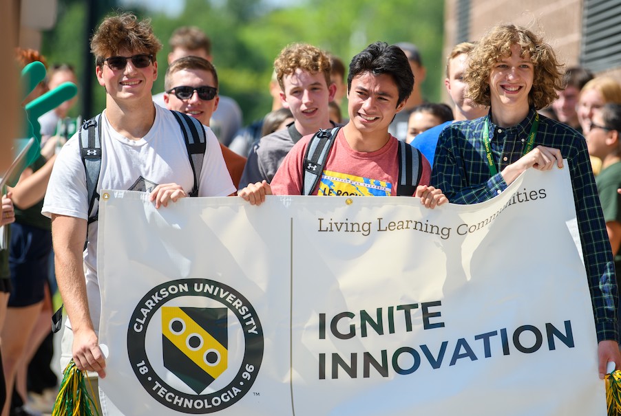 Male students marching with an Ignite banner