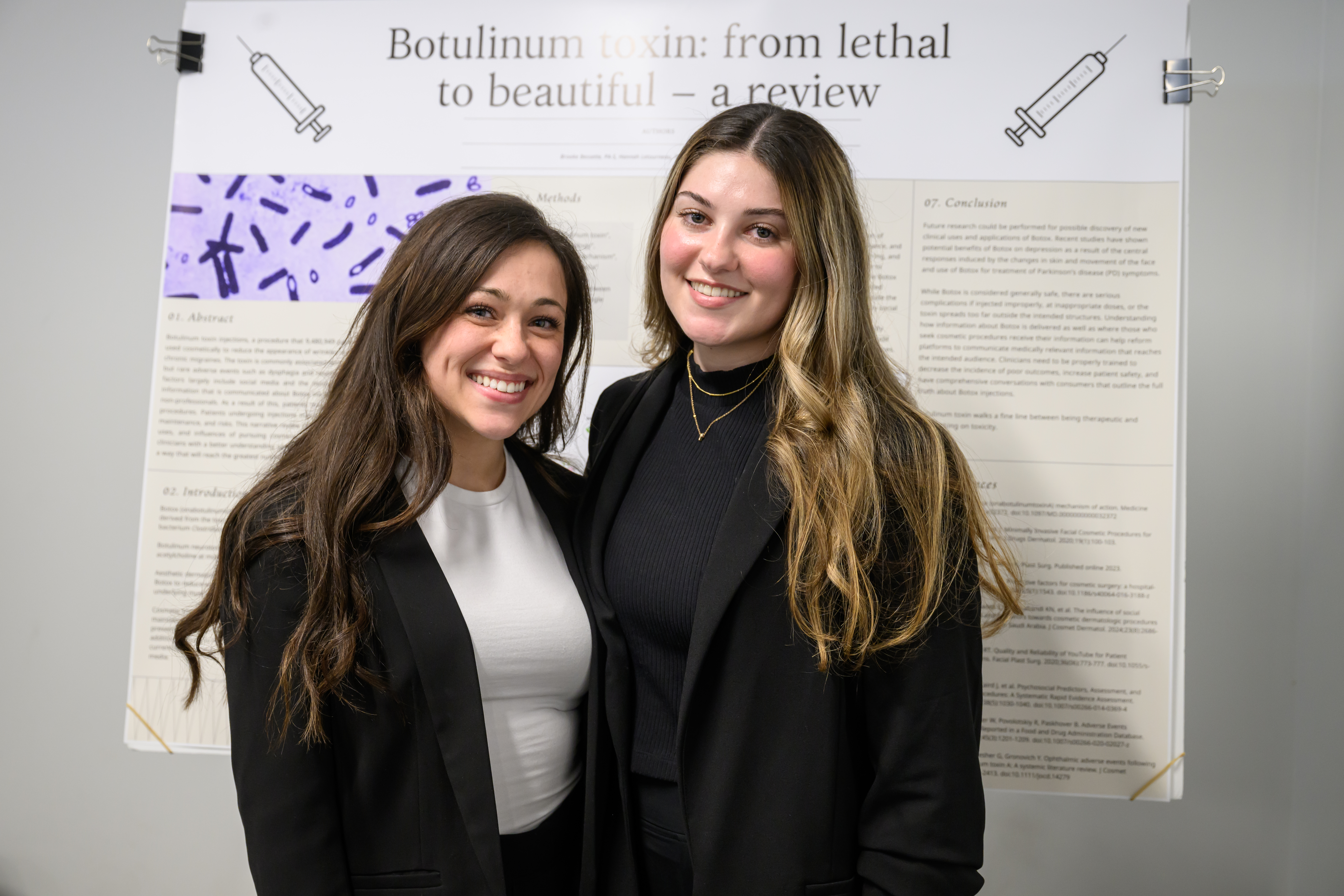 A pair of students having their photo taken with their research.