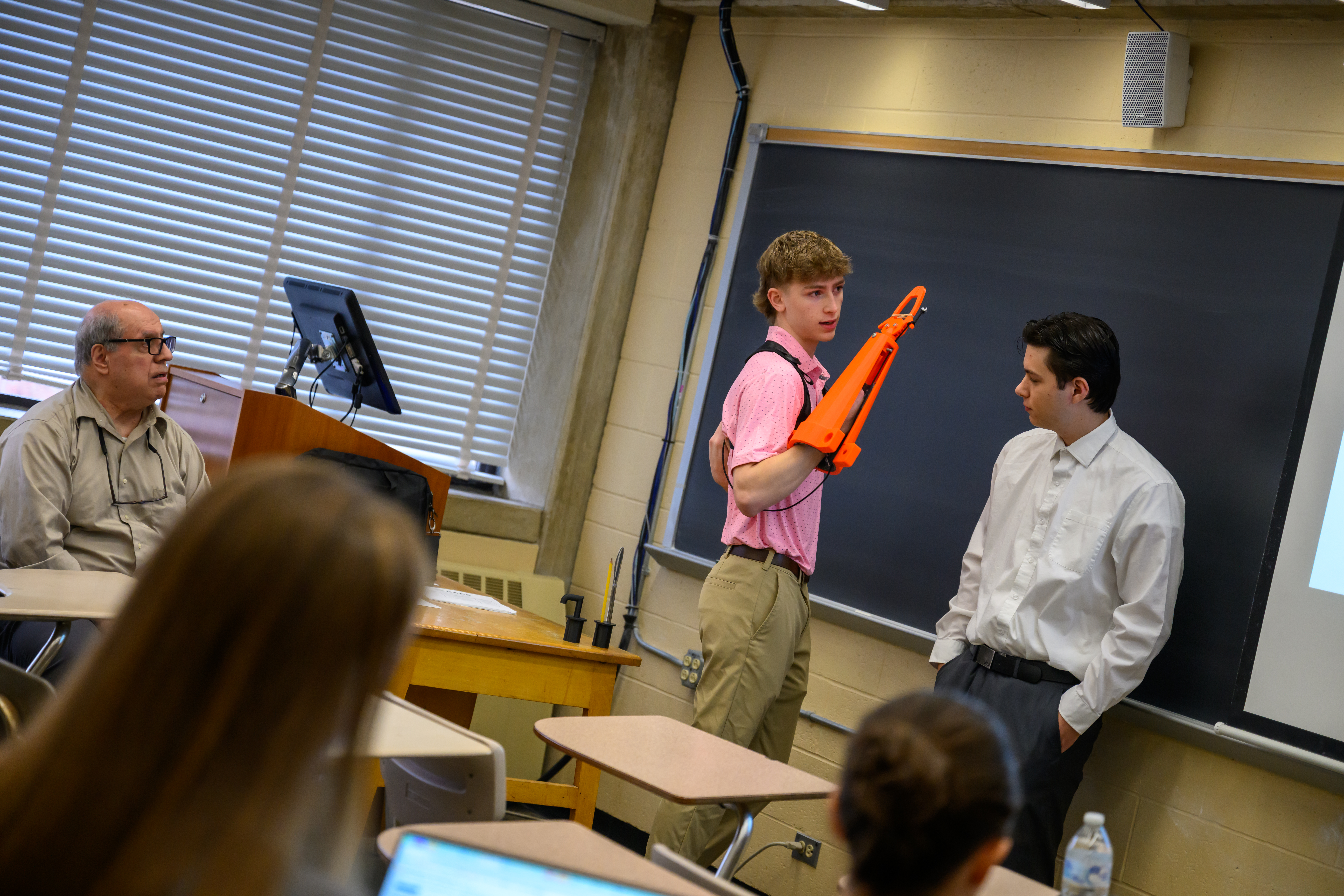 A pair of students showcasing a project to a classroom.