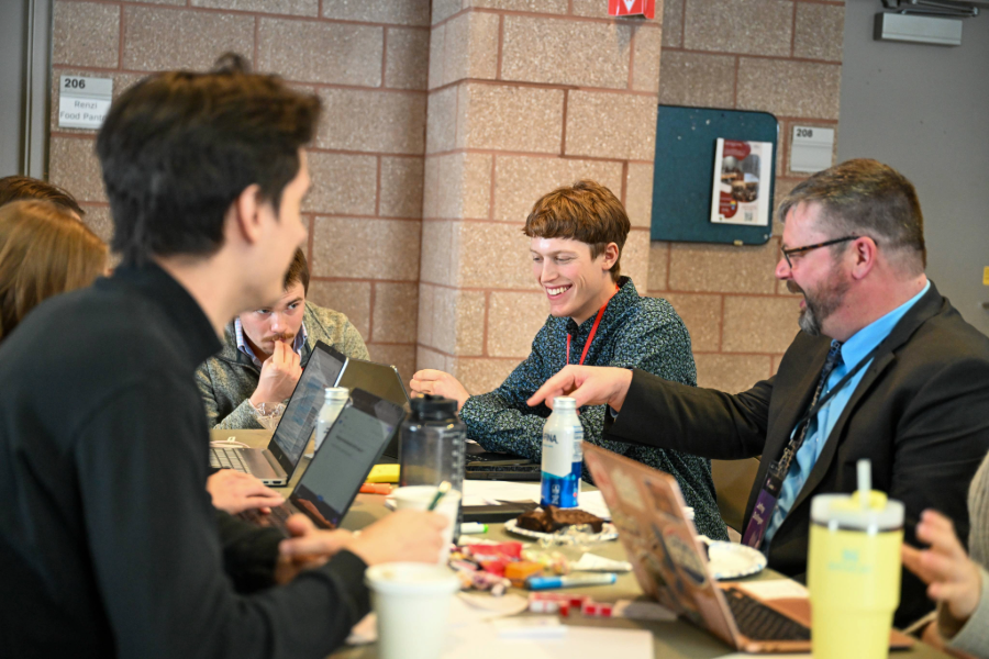 Students talking with industry leaders at a lunch table