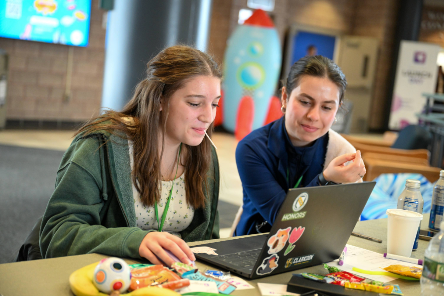 2 students working on a laptop at a table