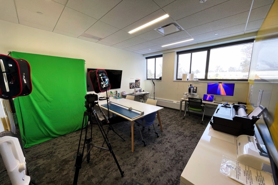 Zoomed out image of the makers loft with a green screen cloth on the left and cameras put around the room