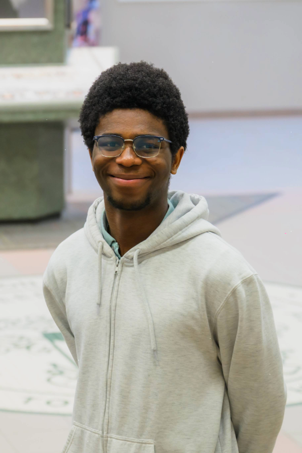 Headshot photo of Kachi Akabogu holding his hands behind him.
