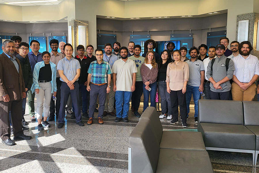 A large group of Clarkson students and faculty pose for a photo celebrating a student induction into Institute of Electrical and Electronics Engineers (IEEE) 