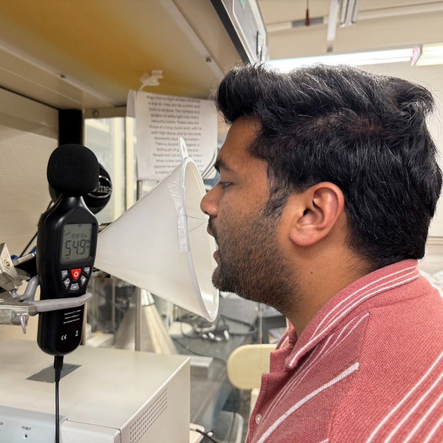 Maheder Singh speaking into a microphone 