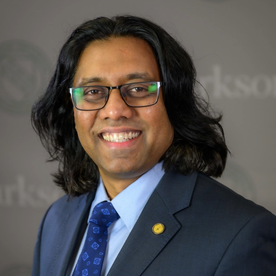 Professor Prashant Headshot photo in a blue collared shirt and suit and tie.
