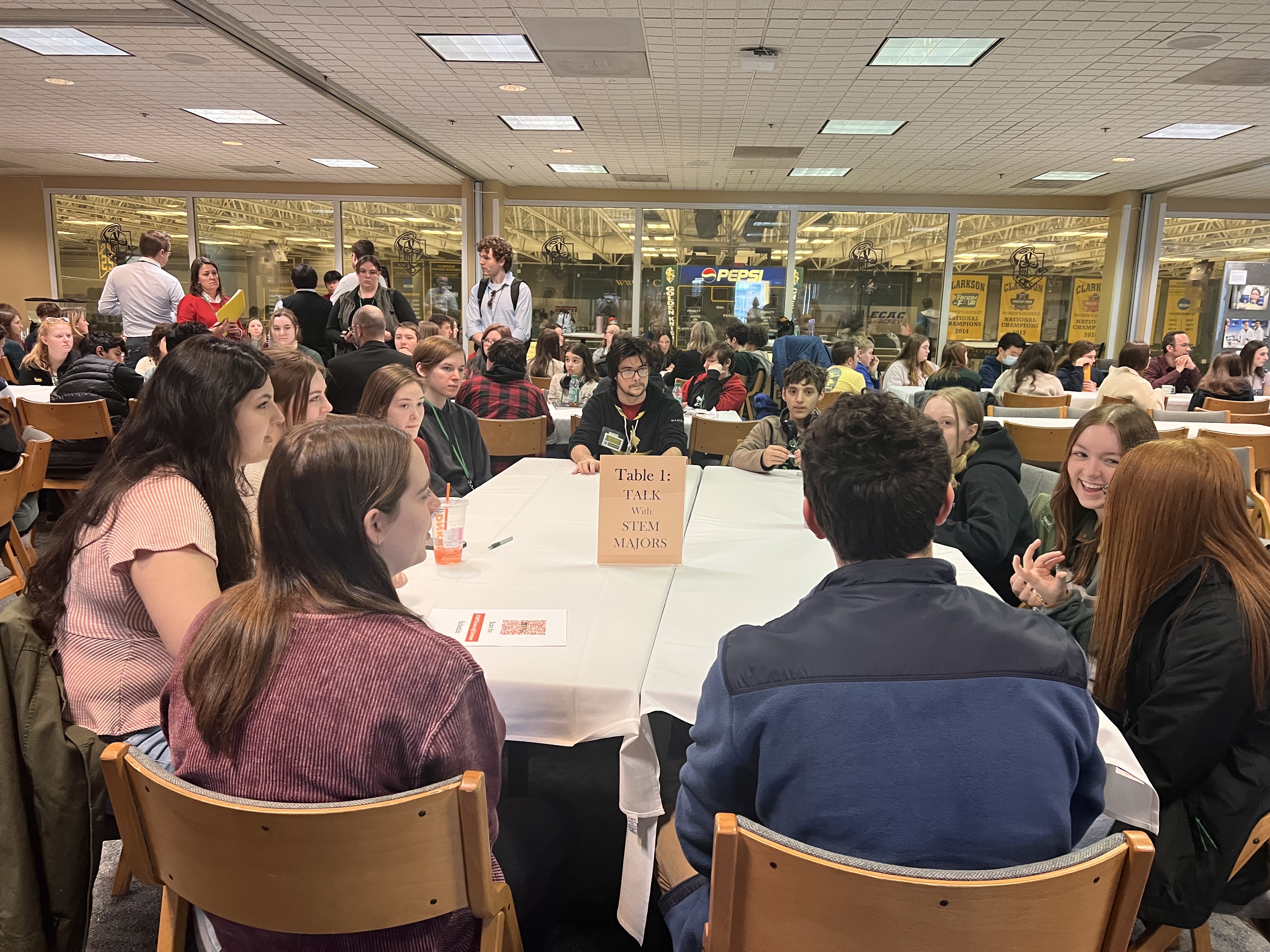 Students sit around a table in discussion at a conference space